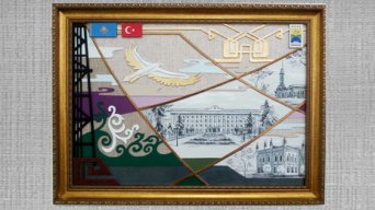 Казахские просторыКартинная плоскостьдекоративного панно разделена линиями на отдельные композиционные сегменты, каждый из них имеет свое содержание. Вместе с тем, горизонтальные линии неба и земли пронизывают всю картину, объединяя все в единый целый рассказ о нашей земле, земле Западного региона Казахстанагорода Уральска.В левой части картины изображена конструкция вышки по добычи нефти и газа. Это символичный рисунок, олицетворяющий богатство нашей земли, ее недра, неисчерпаемые запасы, экономические ресурсы.Рядом с вышкой – орнаментальный элемент, в основе которого заложены казахские растительные узоры. Это символичное изображение нашей красивой и экологически чистой природы.Красота нашего города Уральска отражена фрагментарно в технике роспись. Историческая архитектура в стиле классицизма предстает перед нами в графическом виде, подчеркивая старину зданий. Торжественность коллонад, вертикальный строй линий здания городского акимата перекликается с округлыми очертаниями башен старой мечети и исторического здания Краеведческого музея.Над пейзажем города располагается изображение стилизованной юрты. Издревле юрта у казахского народа олицетворялась с уютом, теплом, центром, который собирает вокруг очага всех родных, близких, гостей. Юрта, в которой можно не только согреться, но и обогатиться духовно. В этой композиции символическое изображение юрты олицетворяет еще и центр, в котором происходит программирование и реализация идей, задач, стоящих перед городским акиматом и жителями города. Герб города Уральска располагается справа. Посредством геральдической символики в гербе отражены вечные духовные и материальные ценности города Уральска – его историческая значимость, природные ресурсы, богатое культурное наследие, основанное на объединении духовных ценностей народов Приуралья.В верхней части композиционного поля размещены флаги двух государств – Казахстана и Турции, народы которых на протяжении столетий являются дружественными.В центральной части композиции парит орел – символ независимости государства, свободного, устремленного к высоким целям в будущее, в высоты мировой цивилизации. В клюве орла находиться веточка артемизии, которая произрастает как в степях Казахстана, так и на просторах Турецкой земли и символически считается эликсиром здоровья. Летит красивая птица с земли казахской, неся в клюве веточку добра, гостеприимства, уважения, миролюбия к турецкому народу. Добро пожаловать в Казахстан!